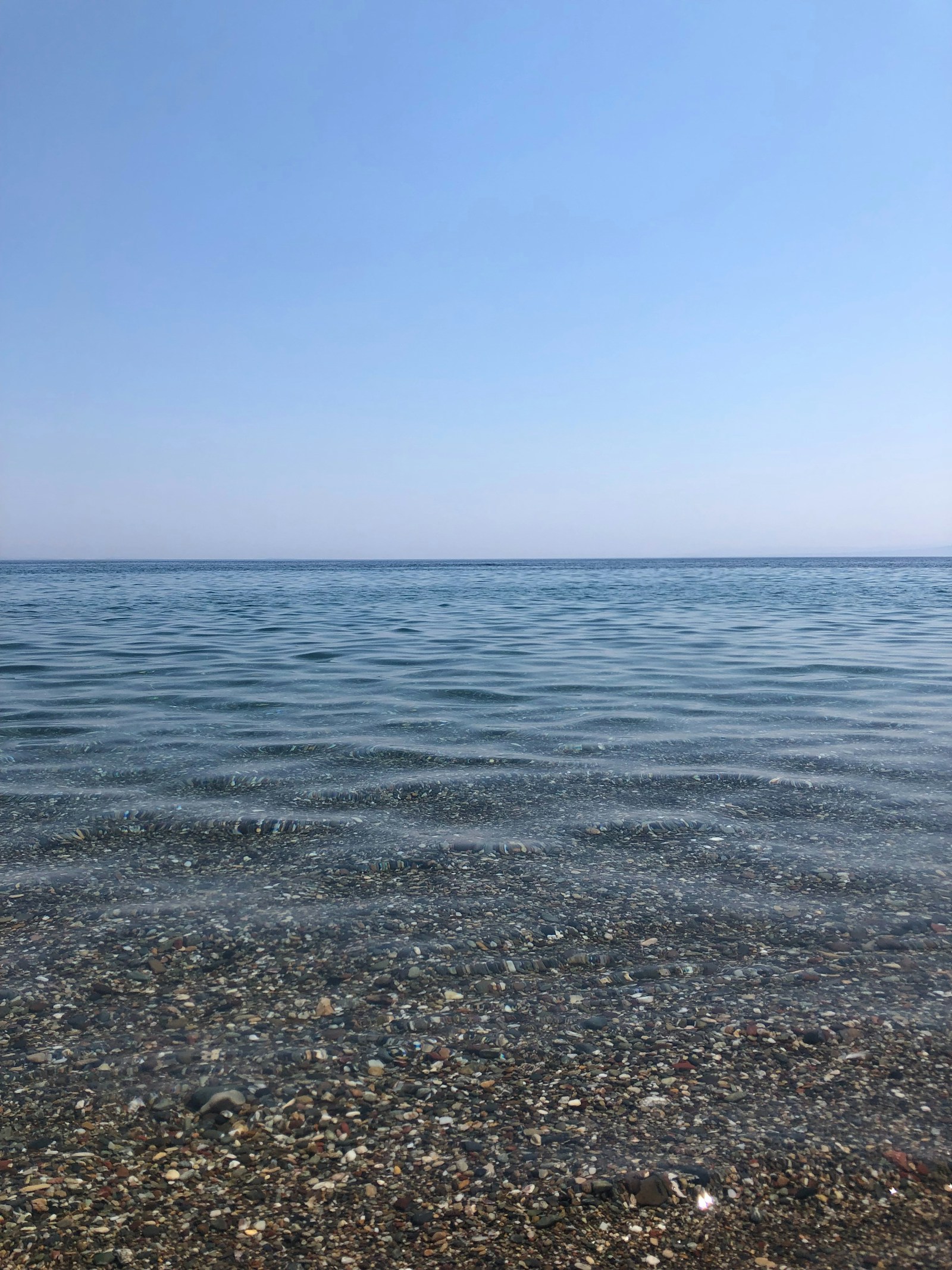 Καθαρή θάλασσα πάνω από βότσαλο